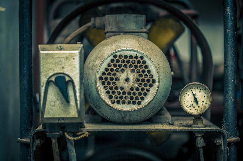 A machine with a motor and gauge, shaped like a sphere.