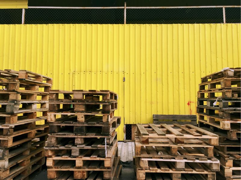 A stack of lumber, plywood, and crates in a box.