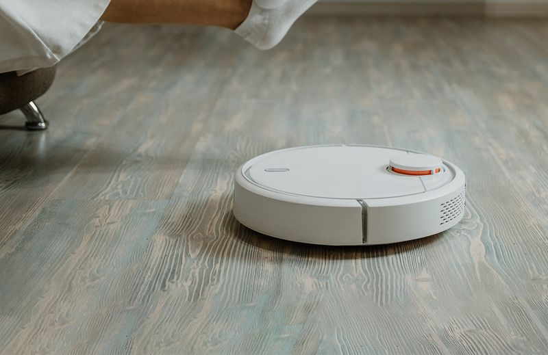 An image of a person using tape on a hardwood floor.