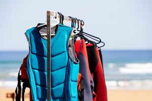 A stack of clothing, including a vest, lifejacket, and bag.