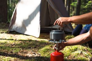 A camping tent with cookware and an adult man.