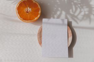 A citrus fruit, specifically an orange and grapefruit, on a business card.